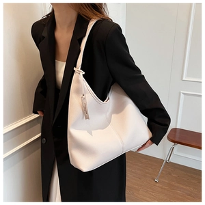 Dettaglio della borsa tote in pelle color crema con etichetta decorativa fashion di tendenza