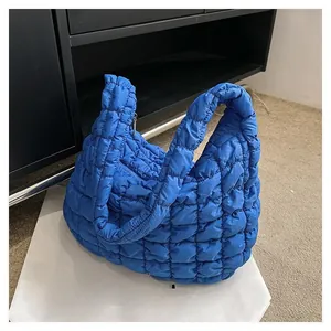 Detailed view of royal blue quilted puffy tote bag with soft texture and wide strap