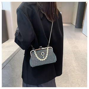 Dettaglio borsa da sera con strass, manico di perle e chiusura con gemma blu