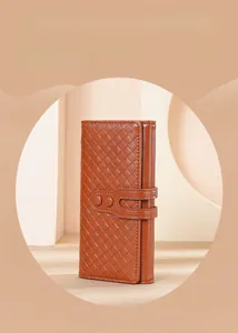 Dettaglio di un portafoglio lungo in pelle marrone intrecciata con chiusura a doppio cinturino