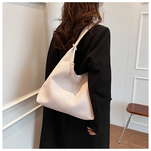 Dettaglio laterale della borsa hobo color crema in ecopelle con trama a grana e tracolla