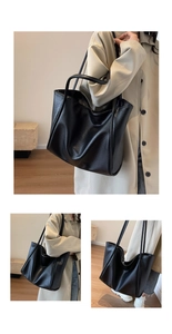 Detail of a large black tote bag with lychee texture and soft shoulder straps for daily use