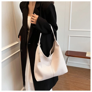 Vista dettagliata della borsa tote grande color crema in morbida pelle a grana sulla spalla