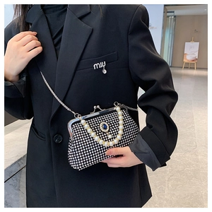 Dettaglio borsa da sera nera con strass, manico di perle e chiusura con gemma blu