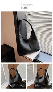 Dettaglio borsa hobo in pelle nera a grana con etichetta moda e vista laterale allo specchio