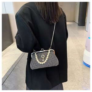 Dettaglio pochette da sera nera con strass, manico di perle e catena in metallo sottile