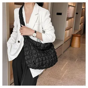 Detail of black quilted cloud tote bag with puffer texture and wide shoulder strap