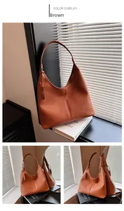 Dettaglio di una borsa tote marrone in pelle martellata con cuciture e cartellino