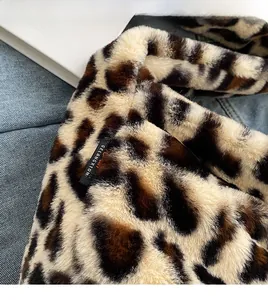 Détail de la texture peluche léopard avec étiquette tissée noire sur le sac à bandoulière