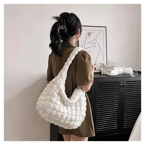 Quilted white cloud shoulder bag featuring textured ruched fabric and braided handle detail