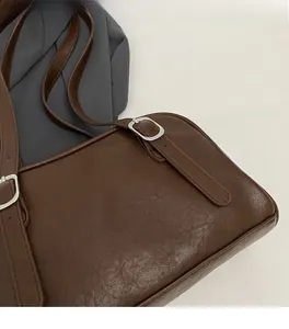 Détail du sac à bandoulière vintage en similicuir marron avec boucle en métal argenté