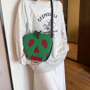 Detailed view of poison apple skull shoulder bag with vibrant green and red leather finish