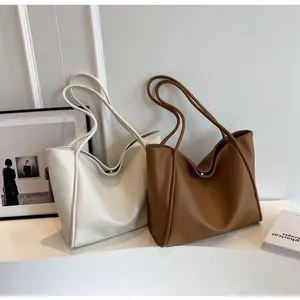 Close-up of large minimalist tote bags in cream white and caramel brown lychee grain leather