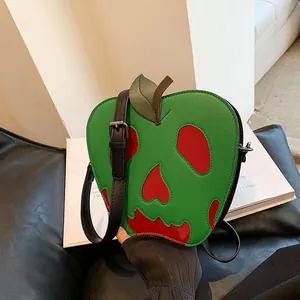 Macro view of poison apple crossbody bag showing green pebbled leather and red drip detail