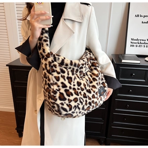 Sac fourre-tout en fausse fourrure léopard porté à l'épaule par un mannequin chic