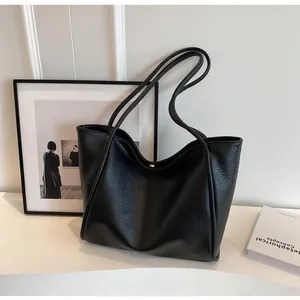 Close-up of black pebble leather tote bag featuring a secure magnetic metal closure