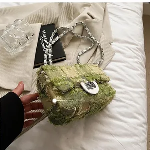 Detail of green tweed crossbody bag showing silver chain strap and frayed edges