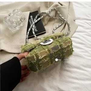 Detail of green tweed quilted bag featuring silver turn-lock and fringe edge textures