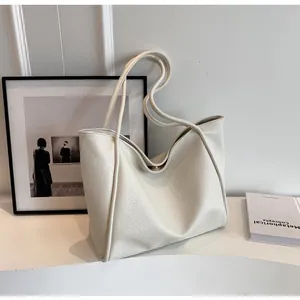 Close-up of white lychee texture tote bag with dual handles on a minimalist table