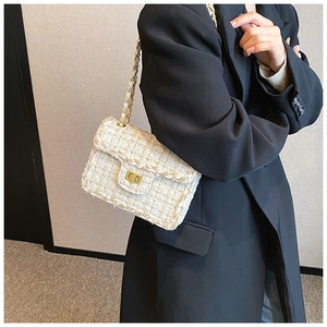 Détail du sac bandoulière en tweed avec chaîne dorée et fermoir pivotant sur le mannequin