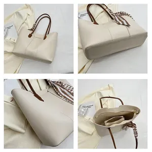 Detail view of off-white tote bag with brown handles, inner pouch, and plaid scarf detail