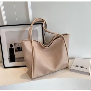 Detailed close-up of beige lychee textured large tote bag on a minimalist table
