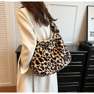 Grand sac cabas en fausse fourrure léopard porté à l'épaule dans un décor minimaliste