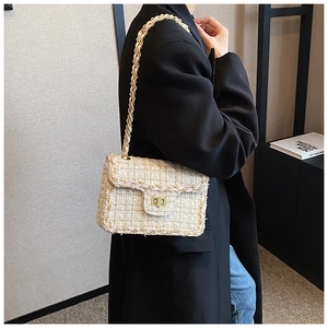 Détail du sac bandoulière en tweed avec fermoir métallique et chaîne dorée ivoire