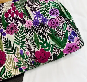 Nahaufnahme von besticktem Blumenstoff an einer Vintage-Muschel-Umhängetasche
