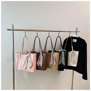 Selection of colorful tote bags with decorative scarves displayed on a clothing rack
