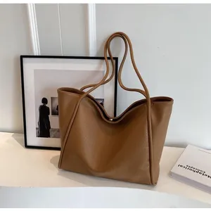 Detail of premium brown lychee texture leather tote bag with sturdy shoulder straps