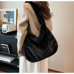 Détail du sac cabas en peluche noire douce avec étiquette ours et texture duveteuse