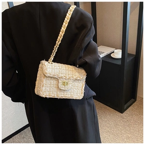Détail du sac à rabat en tweed avec fermoir doré et bandoulière chaîne sur modèle