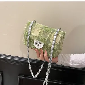Detail of green tweed crossbody bag showing raw edge texture and silver chain strap