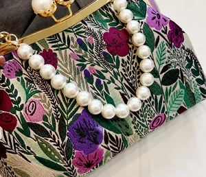 Nahaufnahme der Vintage-Blumenstickerei mit elegantem großem weißem Perlengriff