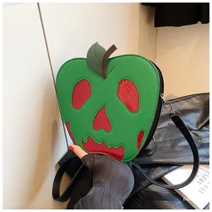 Close-up of Halloween poison apple crossbody bag with skull face and green leaf detail