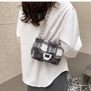 Detail of tweed quilted bag showing frayed edges, silver twist lock and chain strap