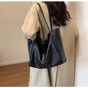 Detailed back view of a black large capacity tote bag with soft lychee texture on model