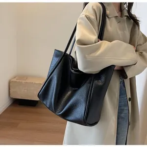 Close-up of a large black tote bag featuring premium lychee pattern leather texture