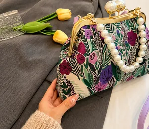 Detailansicht der Blumenstickerei auf Vintage-Tasche mit Perlengriff und Metallverschluss