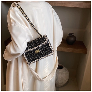 Détail de la texture élégante en tweed noir et blanc avec fil doré et chaîne métallique