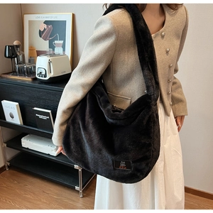 Détail d'un grand sac cabas en fausse fourrure noire avec texture douce et étiquette