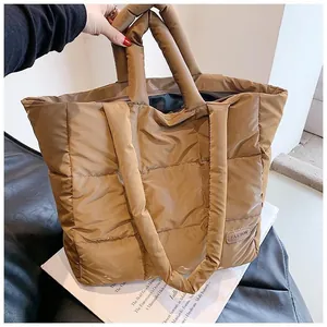 Detail of quilted puffer tote bag featuring fashion tag and square pattern texture
