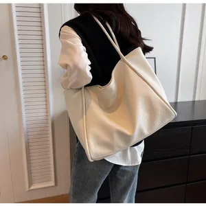 Detailed view of cream white tote bag featuring premium lychee texture and long shoulder straps