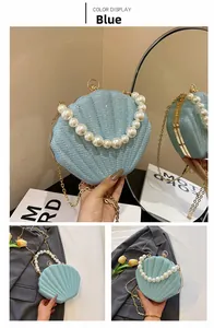 Detail of light blue sequin shell bag with large pearl handle and gold chain strap