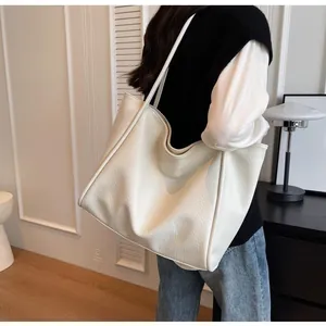Detailed view of the soft cream white lychee pattern leather texture on a large tote bag