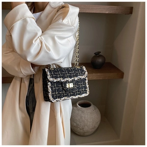 Détail d'un sac bandoulière en tweed avec chaîne dorée et fermoir métallique porté