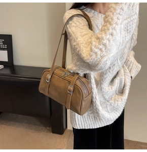 Détail d'un sac sous les bras en cuir marron rétro avec boucle argentée et double zip