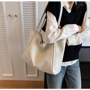 Close-up of the beige large-capacity tote bag featuring a textured lychee grain leather finish