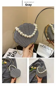 Detail of grey sequin shell evening bag with pearl handle and golden chain strap